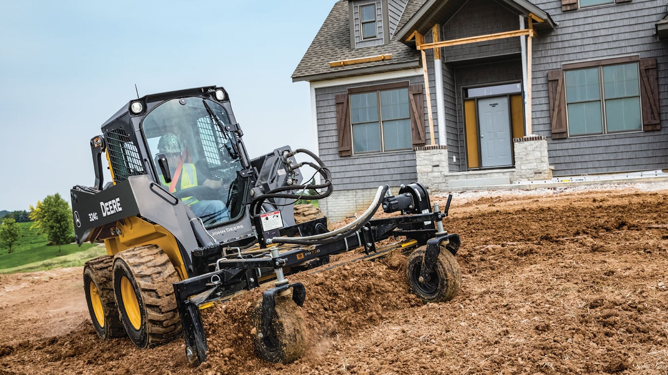 John Deere Skid Steer with Power Rake Attachment at jobsite